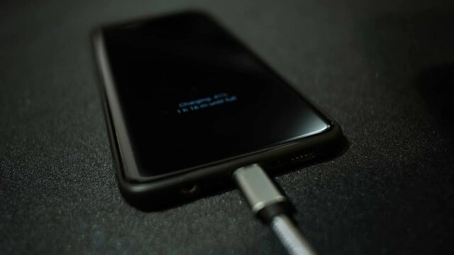 Close up view of man hand while charging smartphone using usb c connector,hi tech 4k