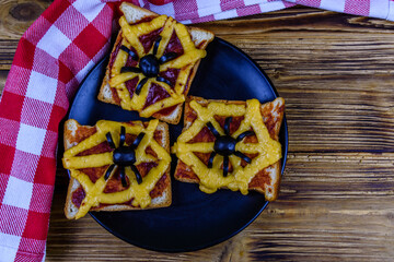 Sandwiches with the spider and spider web on wooden table. Halloween celebration concept
