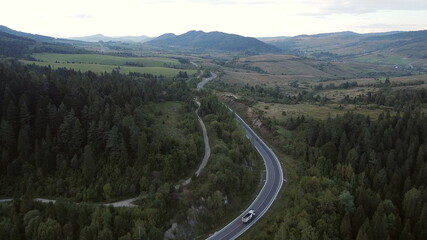 Footage B roll of Aerial view drone flying above landscape serpentine winding road. a car driving in the winding road. Drone 4K Video. road winding on the mountains in summer sunny day. circuitous