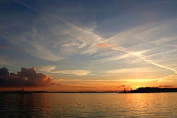 Naklejka premium Beautiful sunset over the sea with lighthouse silhouette, in Split, Croatia.