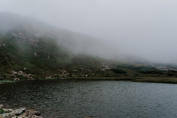 Mountain lake full of fog in rainy day. Windy and storm weather in the karpathian mountains