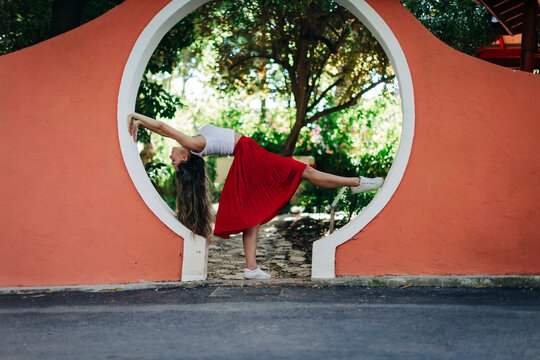 Young woman dancing at entrance against trees in park