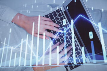 Double exposure of woman hands working on computer and forex chart hologram drawing. Top View. Financial analysis concept.