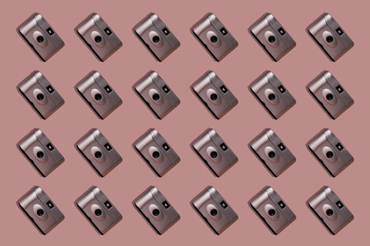 Close-up of retro cameras arranged on pink background