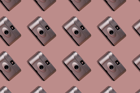 Close-up of old cameras arranged on pink background