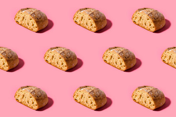 Pattern of fresh loaves of bread against pink background