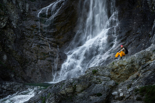 Male hiker sitting on rock against waterfall, Otscher, Austria