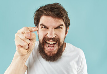 Emotional bearded man on a blue background cropped view of gesticulating with his hands