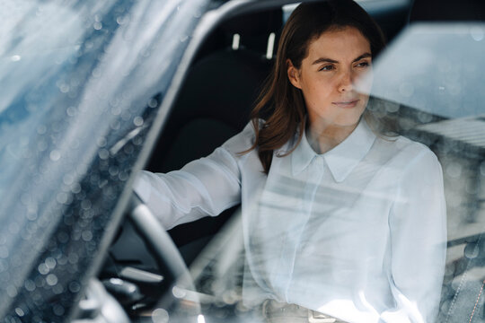 Fototapeta Businesswoman looking away while sitting in car