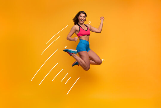 Sport woman jumps on a yellow background. Happy and joyful expression.