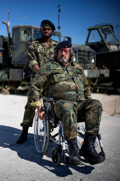 Army soldier helping military office sitting on wheelchair