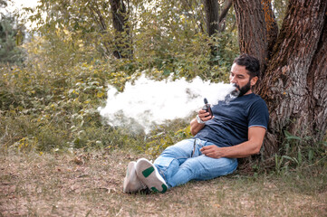 Naklejka na ściany i meble Modern man vaping and releases a cloud of vapor. Vaping concept.