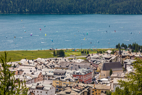 Switzerland, Canton of Grisons, Silvaplana, Lakeshore town in summer with kite surfers in background