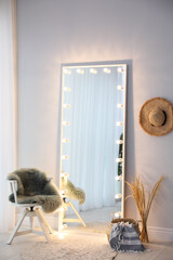Full length dressing mirror with lamps in stylish room interior