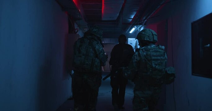 Unrecognizable soldiers examining dark corridor