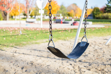 Swing on playground in park in autumn without people
