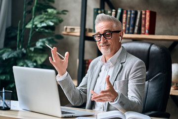 Fototapeta premium Smiling man chatting with a colleague via video communication in the office