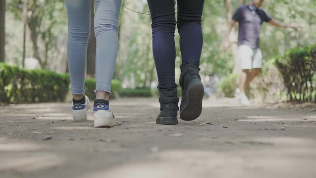 dos personas caminando en una tarde soleada de verano en el parque,  en un dia  de descanso
