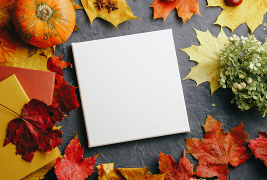 Colorful autumn background with blank canvas board. Mockup poster frame, autumn concept. Top view.