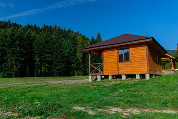 Fototapeta na wymiar wooden cabin house in edge of forest summer nature rural scenic view landscape photography with green outdoor environment space and blue sky background