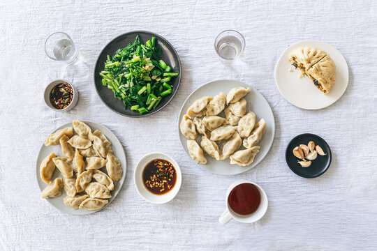 Meal of chinese dumpkings, steamed vegetables and buns