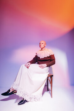 Young hairless model in vintage earrings and jabot