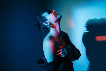 Cyberpunk model with bare shoulder laughing with head thrown back