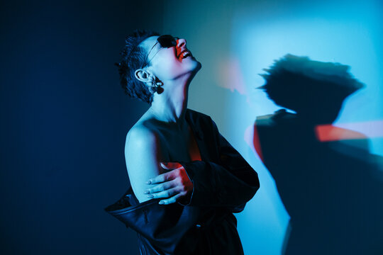 Laughing eccentric futuristic woman in black glasses