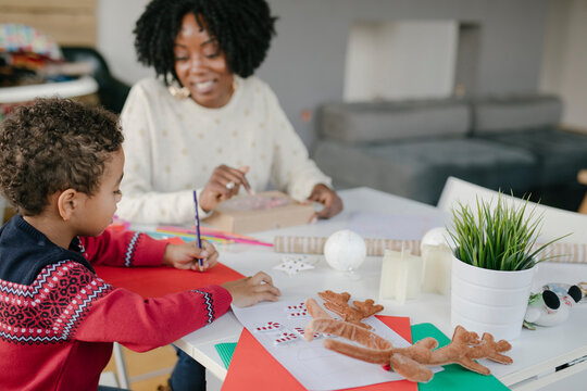 Little boy colouring with his mother