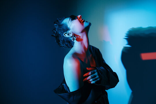 Cyberpunk model with bare shoulder laughing with head thrown back