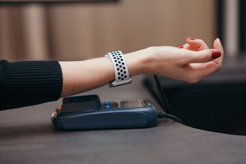 Female customer using smart watch for NFC payment in store