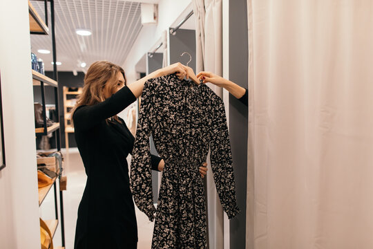Shop assistant helping customer in fitting room