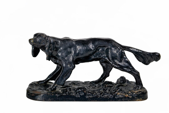 Old cast iron figurine of a black dog isolate on a white background.