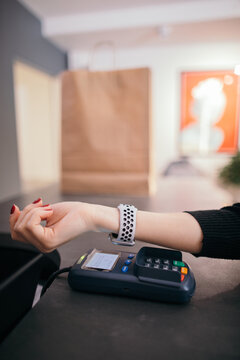 Female customer using smart watch for NFC payment in store