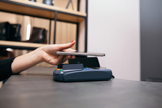 Woman using smartphone for NFC payment in store
