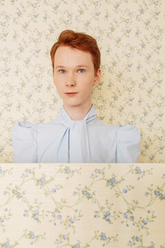 Androgynous guy near panels with floral ornament