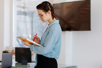 Female employee reading notes in office