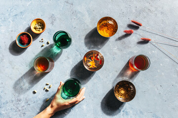 hand holding chai tea in drinking glass with spices, light and shadow
