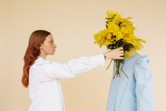 Young woman giving bouquet to anonymous boyfriend