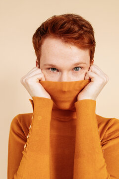 Ginger androgynous model pulling sweater neck