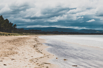 beautiful view of Seven Mile Beach just outside the city of Hobart in Tasmania, Australia on an overcast day with stormy clouds
