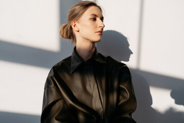 Young model in black shirt against white wall