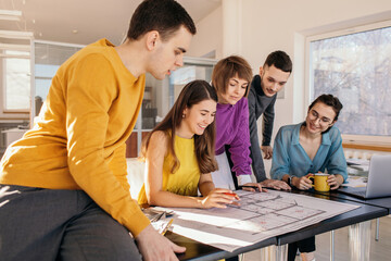 Happy young colleagues working with drafts