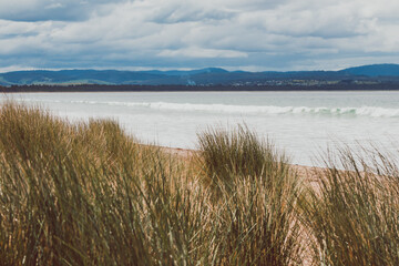 beautiful view of Seven Mile Beach just outside the city of Hobart in Tasmania, Australia on an overcast day with stormy clouds