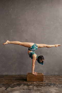 Strong woman balancing on box during yoga workout