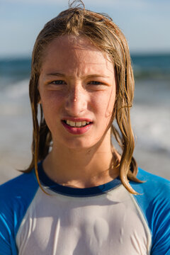 a boy on a beach with wet, long hair