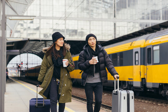 Asian couple on a train station in winter