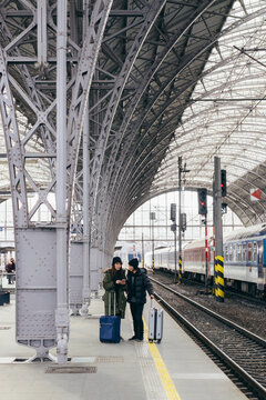 Asian couple browsing on a mobile phone on a train station