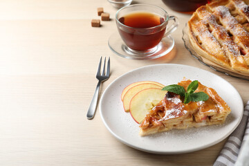 Slice of traditional apple pie served on wooden table. Space for text