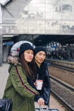 Asian couple waiting for a train in European city